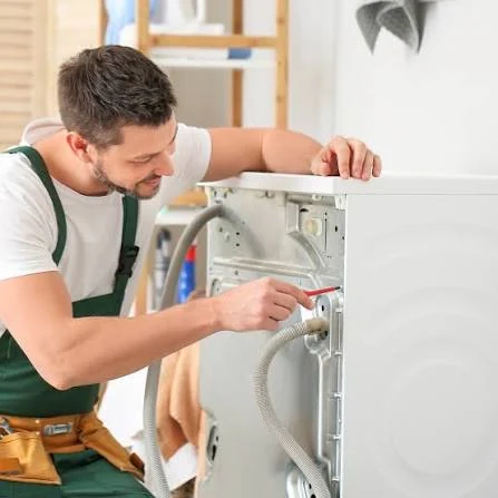 Technician working on the rear panel of a household appliance