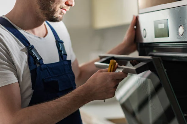 Technician inspecting an oven door with a handheld tool